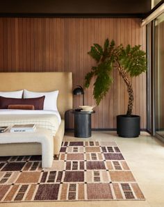 a large bed sitting next to a plant in a bedroom