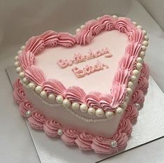 a heart shaped cake with pink icing and pearls