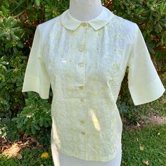 This is a super pretty blouse made by Jean Taylor from the 1950s The material is Shikibo Tetoron  Lightweight and breathable! Tag size is a small This is single stitch and in perfect condition, no flaws, like new, preserved very well! I adore the floral embroidered pattern on it It buttons for closure and has a cute collar Measurements as follows: Pit to pit laying flat is 18.5" inches Width at bottom is 18.5" inches laying flat  Length is 22" inches  I ship priority mail with tracking! Thanks f Fitted Shirt With Floral Embroidery For Daywear, Fitted Vintage Tops With Floral Embroidery, Retro Spring Blouse With Floral Embroidery, Retro Summer Blouse With Embroidery, Fitted Retro Blouse With Floral Embroidery, Retro Short Sleeve Blouse With Floral Embroidery, Retro Embroidered Blouse For Summer, Vintage Blouse With Floral Embroidery For Daywear, Retro Fitted Blouse With Floral Embroidery