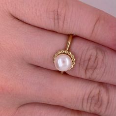 This lovely cultured pearl ring is the perfect gift for a loved one or a great self purchase. The nice size pearl has a gold beading design that is very simple but elegant. The pearl is the most desirable color with a nice white color with rose hues. This ring is a size 6.5 but is sizable. Just let our shop know what size your need and our in house jeweler can take care of that. The details for this beautiful ring are listed below:Metal Quality: 14 K Yellow Gold Gemstone: Freshwater Pearl Gemsto White Pearl Ring With Pearl Chain, Elegant Pearl Chain Ring, Elegant Pearl Rings With Pearl Chain, Open Ring With Pearl Drop, Pearl White Ring With Pearl Chain, White Akoya Pearl Ring With Pearl Drop, Delicate Pearl Drop Ring As Gift, Anniversary Pearl Open Ring, Anniversary Pearl White Rings With Pearl Charm