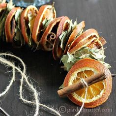 an apple and orange slice are wrapped in twine to look like a caterpillar