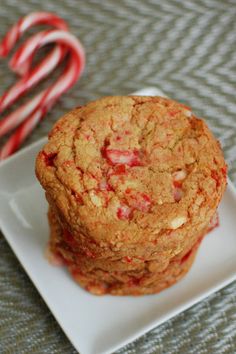 two cookies on a plate with candy canes in the background