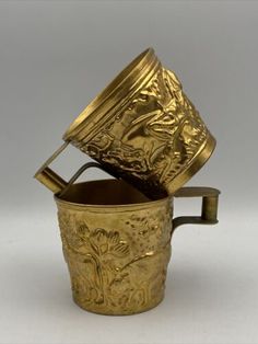 an antique brass cup with lid and handle