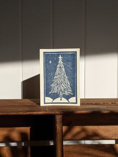 a blue and white christmas card sitting on top of a wooden table