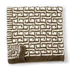 a brown and white knitted blanket sitting on top of a table