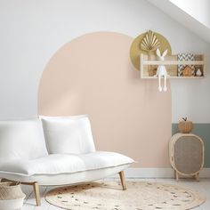 a white couch sitting on top of a rug in a living room next to a shelf