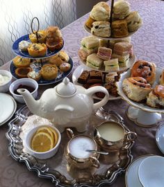 a table topped with plates and cups filled with pastries