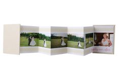 an open photo album with three pictures on it and the cover opened to show wedding photos