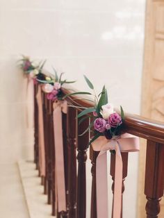 pink and white flowers are tied to the banisters