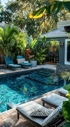 an outdoor swimming pool surrounded by greenery and lounge chairs in the middle of it