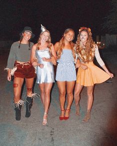 four women dressed up in costumes posing for the camera