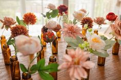 several bottles with flowers in them sitting on a table