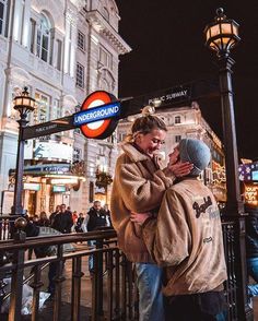 two people embracing each other on the street