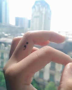 someone is holding up their tiny ring with the word love written on it in front of a cityscape