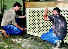 two men working on a fence in the yard