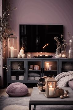 a living room filled with furniture and candles on top of the coffee table in front of a flat screen tv