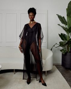 The Diana Kaftan serves sheer luxury romance and is made from 100% silk organza. Crisp and smooth with a matte finish, this black sheer kaftan can be layered over your favorite swimsuit or bodysuit. Diana is intentionally minimal to allow you to style and accessorize to your hearts desire. Elevate your lounging, evening events and resort wear with its breezy high side slits and ultimate versatility. You can style Diana with wide legged trousers or jeans for a more fun look. We recommend dressing Sheer Beachwear For Party, Black Sheer Swimwear For Beach Cover-up, Party Sheer Beachwear, Party Beachwear With Sheer Details, Fitted Sheer Chic Cover-up, Chic Fitted Sheer Cover-up, Sleek Swimwear For Summer Evenings, Sleek Swimwear For Evening In Summer, Sleek Evening Swimwear For Summer