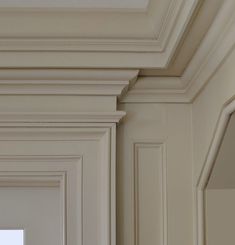 an empty room with white walls and moldings