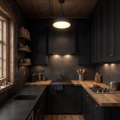 a kitchen with black cabinets and wooden counter tops is lit by a round light above the sink