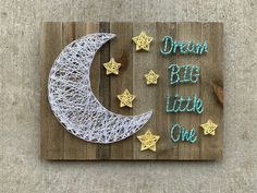 a string art sign with the words dream big little one written on it and stars