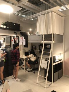 two women standing in front of a loft bed