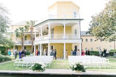 an outdoor wedding venue with white chairs and flowers in front of the ceremony area, surrounded by palm trees