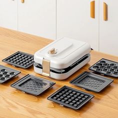 a waffle maker sitting on top of a wooden table next to other pans