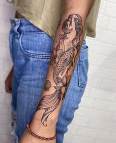 a man's arm with a fish tattoo on it