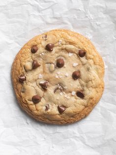 a chocolate chip cookie sitting on top of white paper