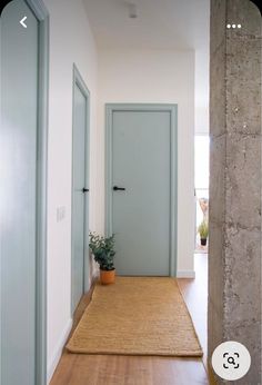 an empty hallway with two doors and a rug on the floor