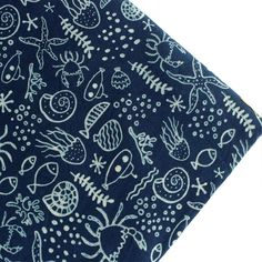 a blue and white bandana with fish, seaweed, starfish, corals and other marine creatures on it