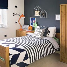 a bed room with a neatly made bed next to a wooden dresser and two windows