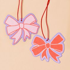 two tags with bows hanging from red string