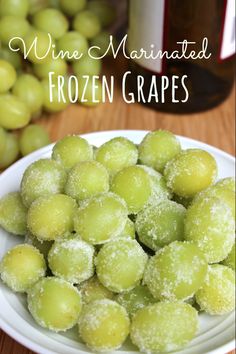 some grapes are on a white plate with the words wine marinated frozen grapes