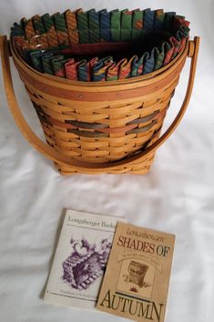 a basket filled with books next to a book on top of a white tablecloth