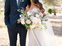 a bride and groom pose for a wedding photo