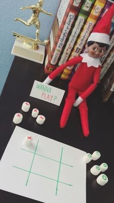 an elf is playing tic - tac toe game on the table next to some books