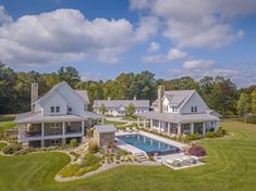 an aerial view of a large house with a pool in the front yard and landscaping around it