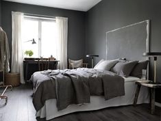 a bedroom with gray walls and white bedding