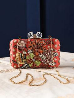 This product has been crafted by hand and may have slight irregularities or imperfections in color or embellishment. These irregularities are the result of the human involvement in the process and add to the finished products charm while ensuring you have a one-of-a-kind piece. Red Embellished Rectangular Bag, Designer Red Embroidered Bag, Embroidered Red Pouch Clutch, Red Embroidered Pouch Clutch, Festive Rectangular Bag With Floral Embroidery, Party Multicolor Floral Embroidered Bag, Party Bags With Floral Embroidery In Multicolor, Party Bags With Floral Embroidery, Rectangular Embellished Bags For Gifts