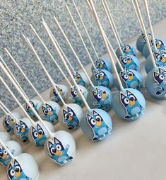 blue cake pops with cartoon characters on them are lined up next to toothpicks