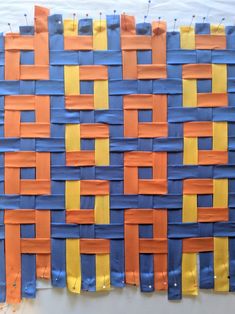 an art project made out of strips of blue, orange and yellow paper