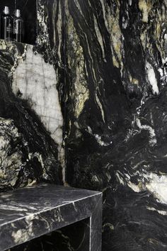 a black and white marble bathroom with a bench