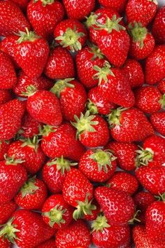 a bunch of strawberries that are laying on top of each other