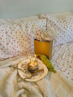 a birthday cake with lit candles sitting on a plate next to a bag and stuffed animals