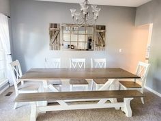 a dining room table with benches and a mirror