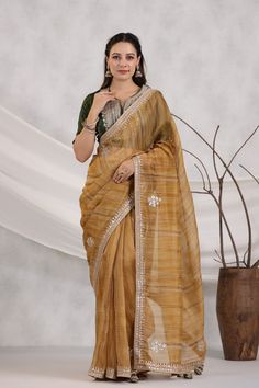 Shop beautiful mustard striped organza saree online in USA with green embroidered blouse. Make a fashion statement on festive occasions and weddings with designer suits, Indian dresses, Anarkali suits, palazzo suits, designer sarees, sharara suits, Bollywood saris from Pure Elegance Indian fashion store in USA.-full view Festive Pre-draped Saree In Slub Silk With Gota Work, Unstitched Cotton Silk Saree With Gota Work, Festive Saree With Sheer Dupatta In Slub Silk, Festive Yellow Tussar Silk Pre-draped Saree, Festive Slub Silk Saree With Sheer Dupatta, Yellow Organza Blouse Piece For Designer Wear, Slub Silk Saree For Navratri Party, Yellow Anarkali Style Organza Pre-draped Saree, Gold Organza Pre-draped Saree With Gota Work