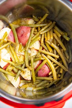 potatoes, green beans and onions in a pot on the stove top with seasoning