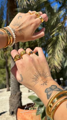 two people holding hands with tattoos on their arms and wrist, palm trees in the background