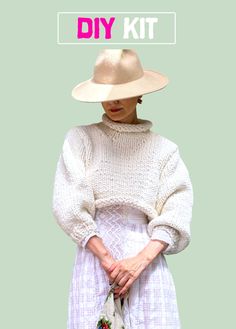 a woman in a white dress and hat with her hands on her hip while holding a purse